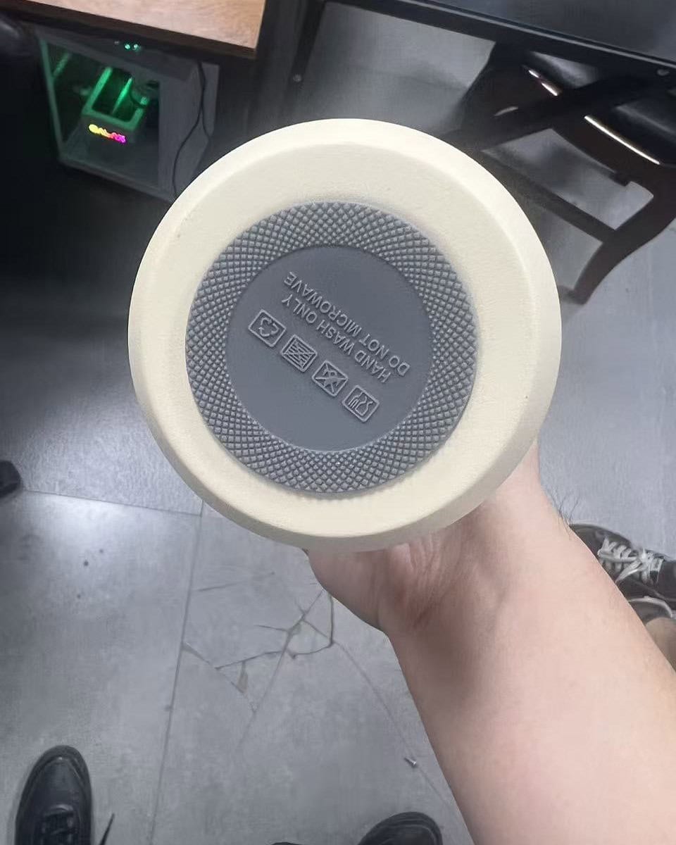 Gray silicone anti-slip pad fitted to the bottom of a stainless steel tumbler