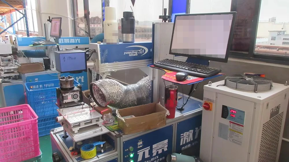 Laser marking workstation with a rotary fixture, extraction hose and computer monitor