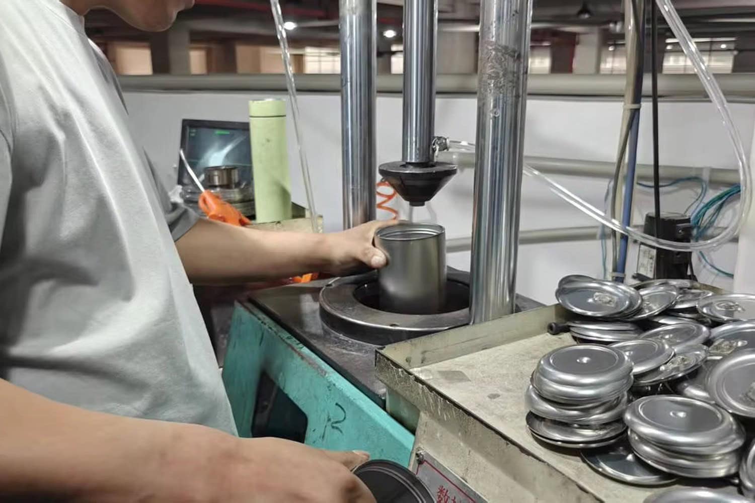 Stainless steel tumbler bottom plates prepared at a cup-body production workstation