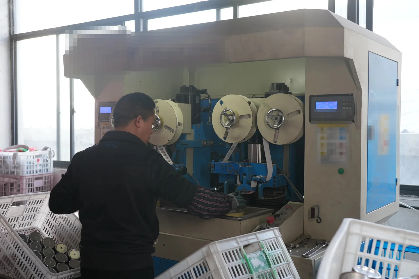 Operator setting up production equipment for drinkware components