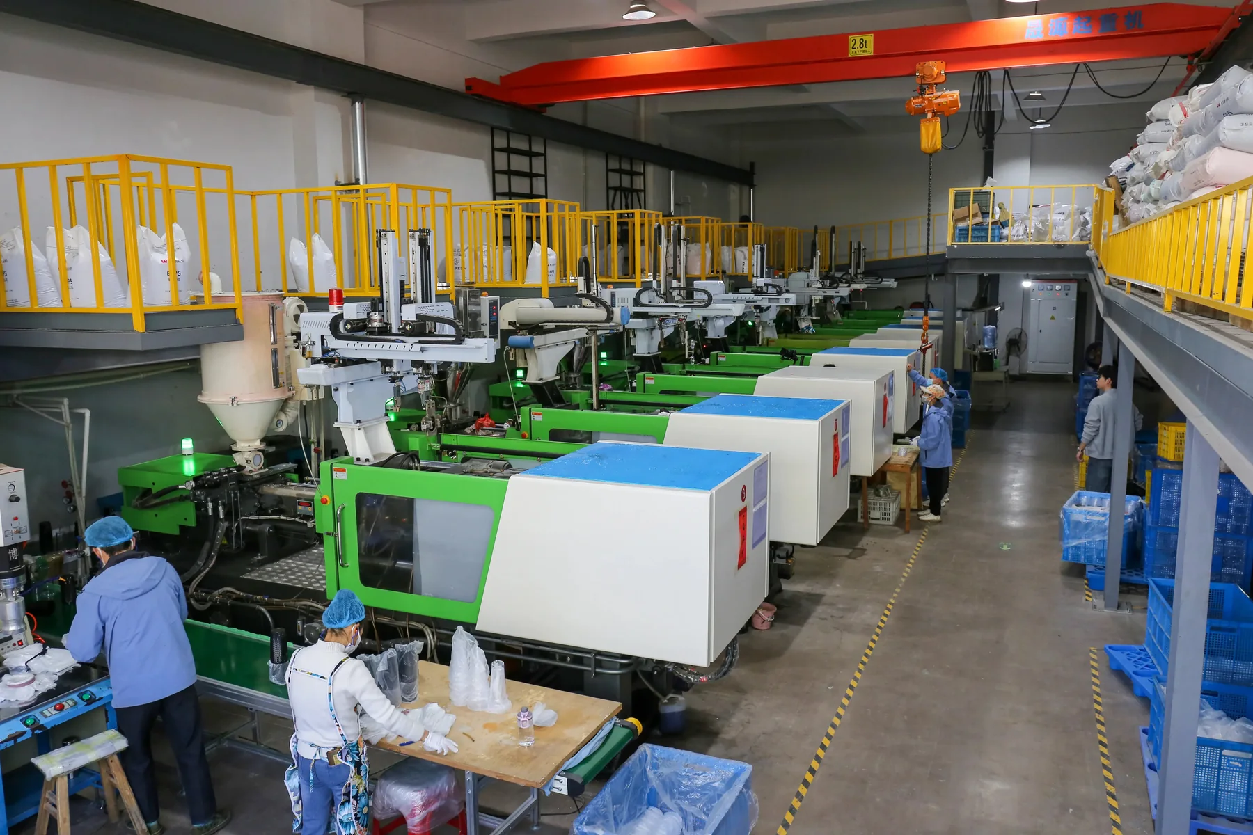Wide view of the BG Drinkware component production workshop with operators and molding equipment